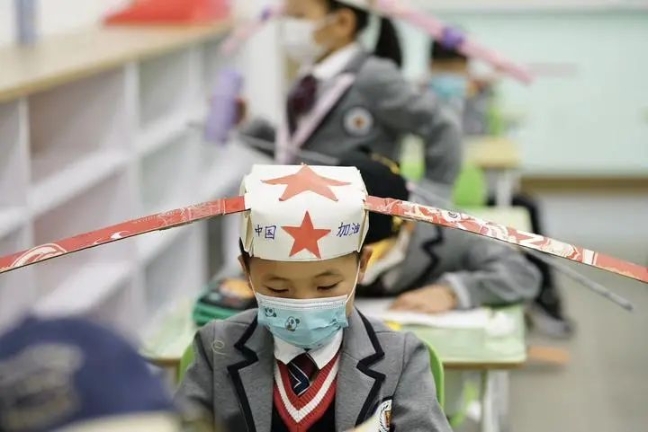 У Китаї діти прийшли до школи в метрових капелюхах, щоб тримати відстань