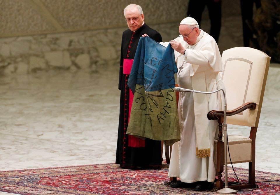 Папа Франциск розгортає український прапор, надісланий із Бучі.