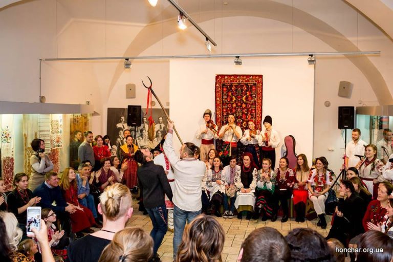 Fall festivals in Ukraine: The boy tries to reach the kalyta at the traditional Ukrainian evening party