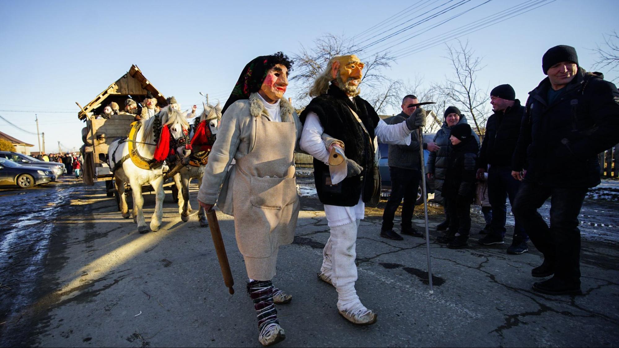 The characters of the grandfather and grandmother walk through the village during the Malanka festival.